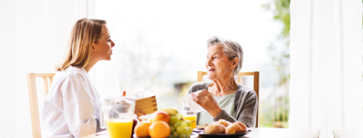 caregiver assisting senior woman in eating